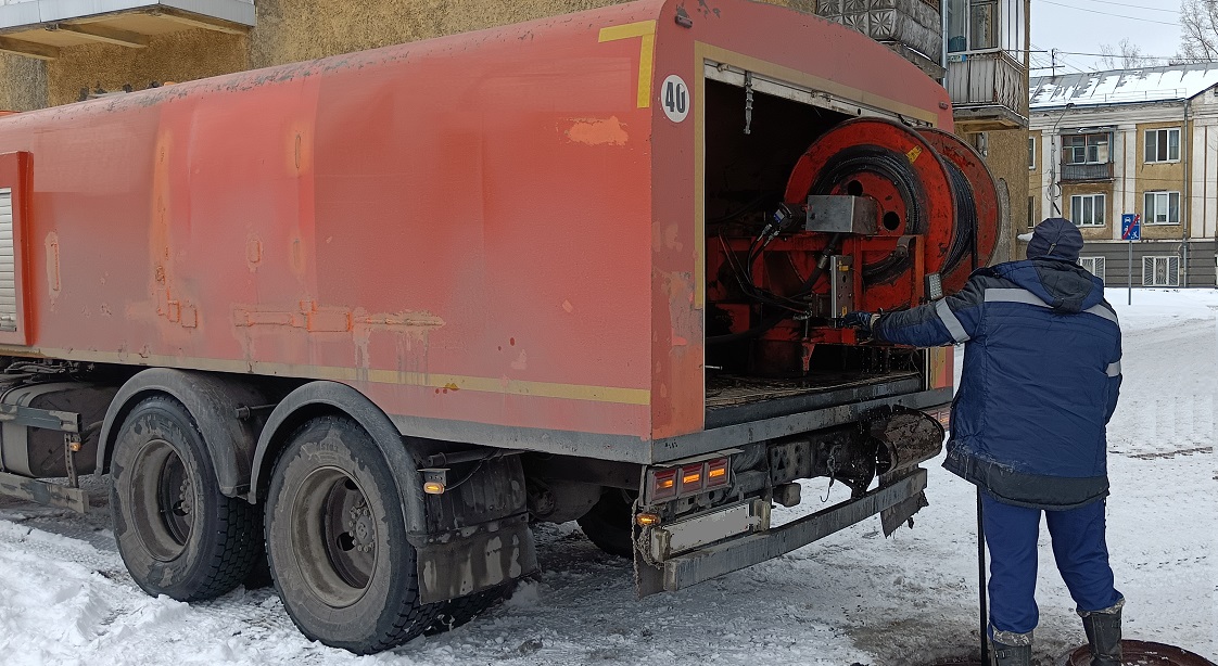 Каналопромывочная машина и работник прочищают засор в канализационной системе в Бежецке